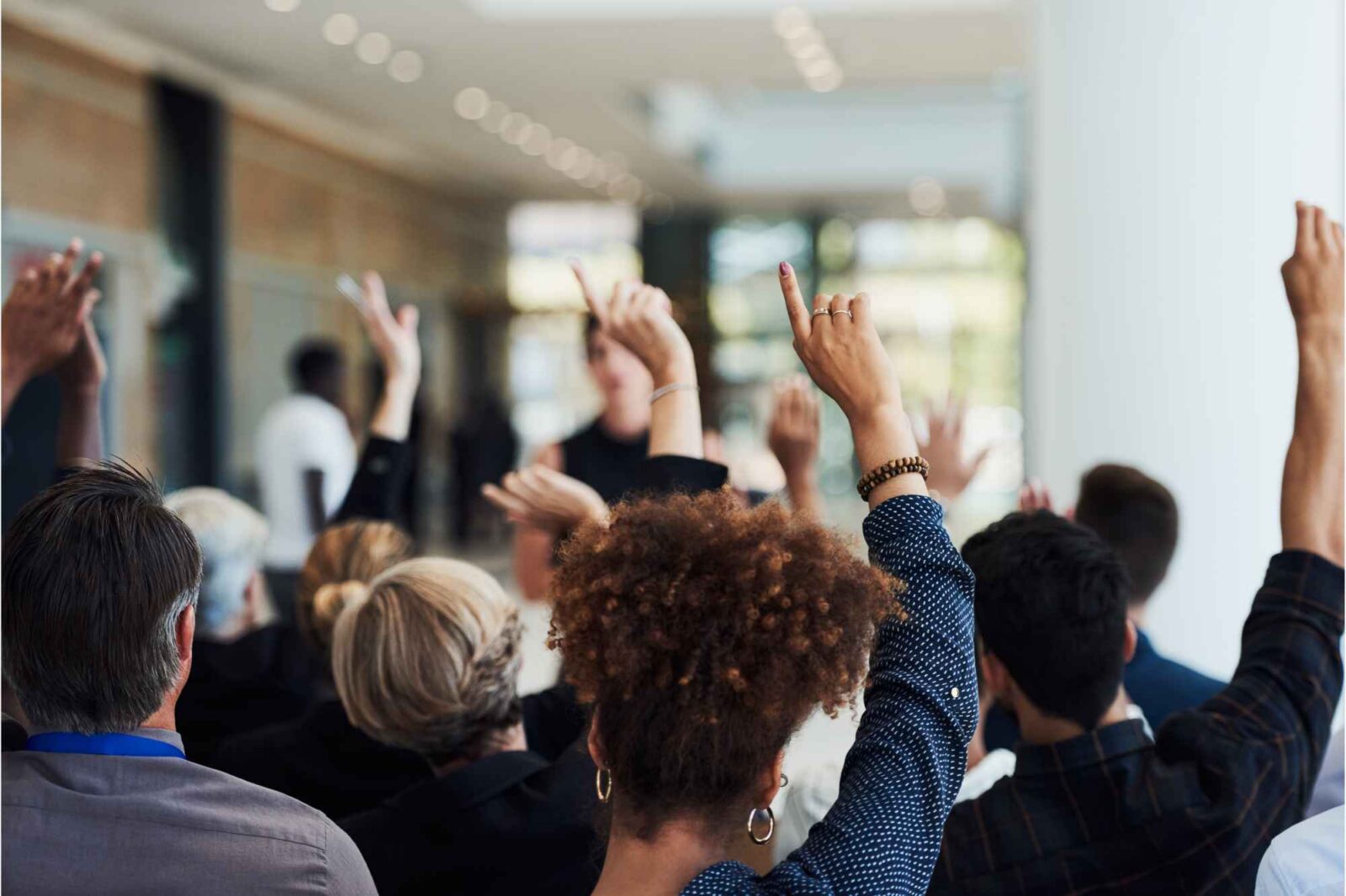 Menschen heben ihre Hände bei Eigentümerversammlung