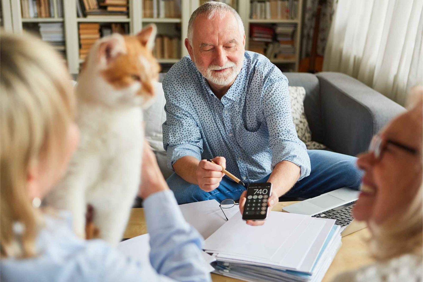 Mann mit Taschenrechner macht Steuererklärung gemeinsam mit Frau und Katze