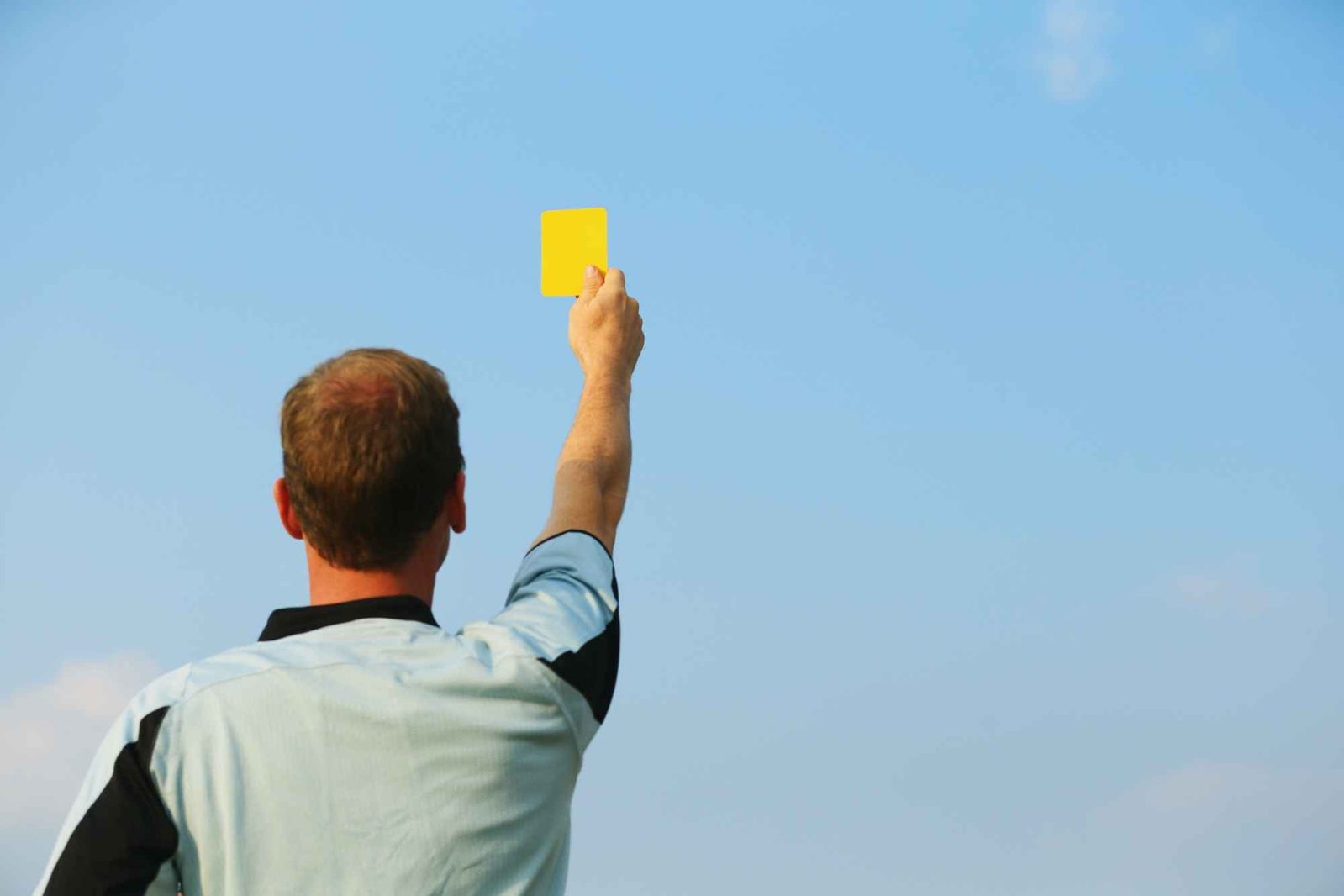 Schiedsrichter zeigt gelbe Karte