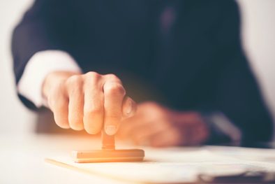 Baugenehmigungen: Mann stempelt Dokument