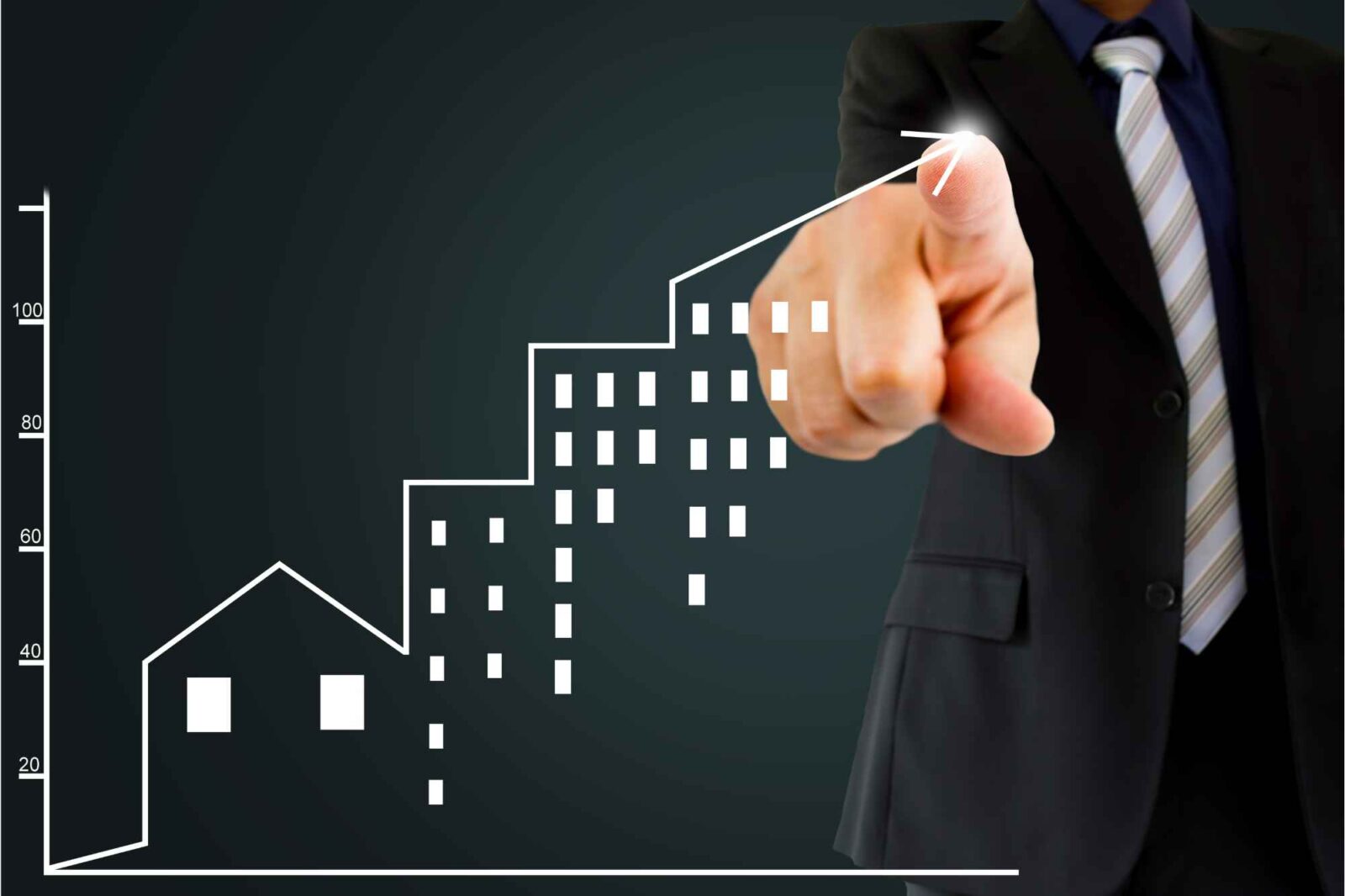 Mann in Anzug zeigt auf Diagramm zu Immobilienpreisen