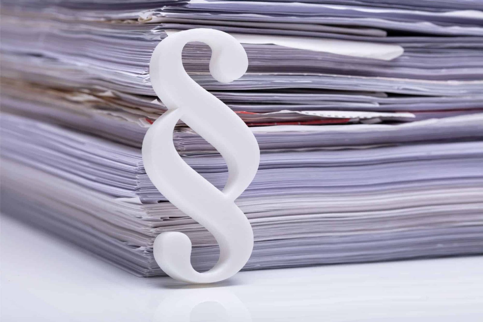 Paragraphensymbol vor Unterlagenstapel