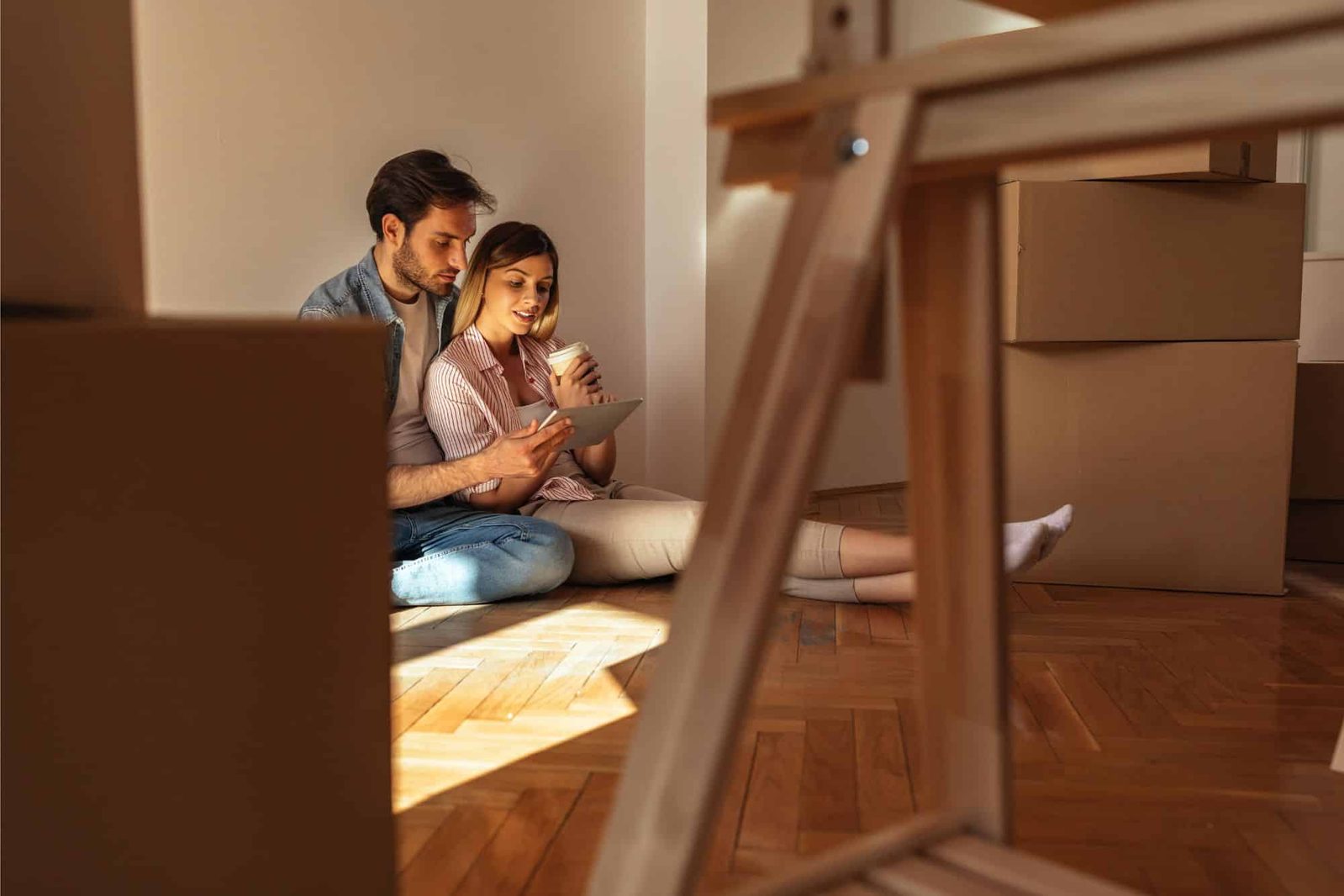 Paar sitzt auf Boden in frisch gekaufter Wohnung