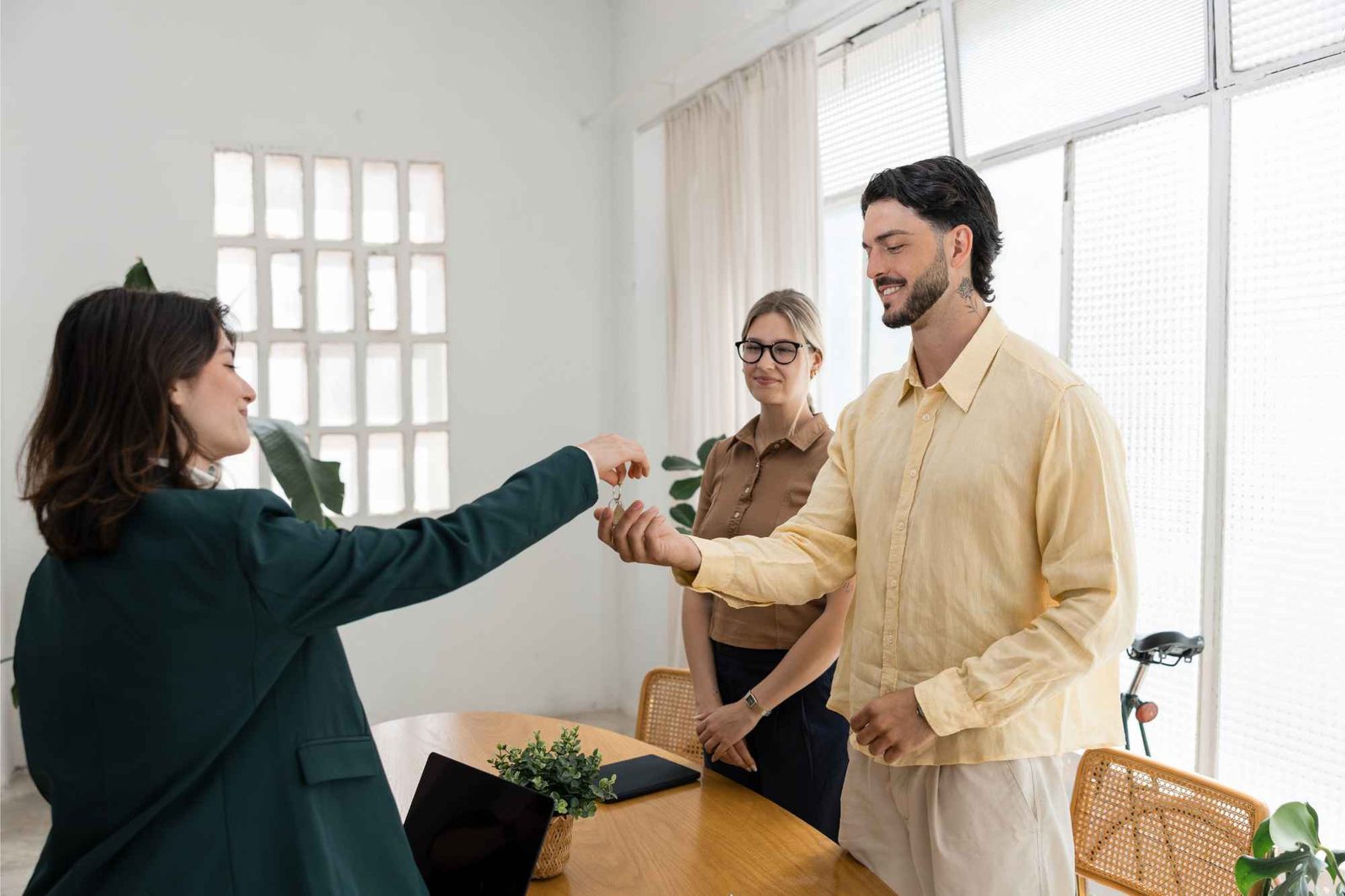 Vermieterin übergibt Schlüssel an junges Paar in Wohnung